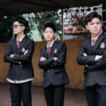 Group of teenagers standing confidently in school uniforms outdoors, showcasing unity and style.