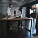 Doctors and filmmaker collaborating in an office setting, highlighting teamwork.