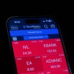 Close-up of a smartphone displaying a stock market app showing red losses.