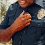 Close-up of a security officer using a radio outdoors, showcasing professional security attire.