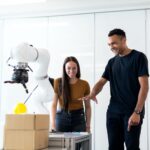 Two engineers collaborating on testing a futuristic robotic prototype in a modern indoor lab.