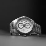 Sophisticated black and white macro shot of a luxury silver wristwatch showcasing precision details.