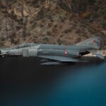 Turkish F-4 Phantom fighter jet flying over a scenic lake and cliffs in Türkiye.
