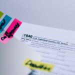 Close-up of 1040 U.S. tax form with colorful sticky notes for organization.