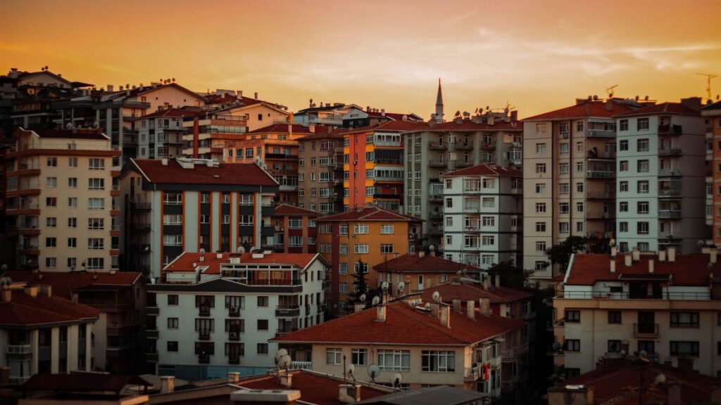 Dramatic sunset over Ankara's dense urban architecture with colorful apartment buildings.