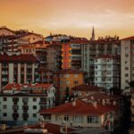Dramatic sunset over Ankara's dense urban architecture with colorful apartment buildings.