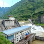 Hydroelectric dam set against lush green mountains, showcasing power generation.