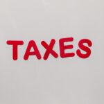 Simple and bold image of the word taxes in red letters on a white background.
