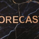 The word 'FORECAST' in wooden letters on a dark marble background.