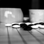 Artistic capture of a Go board with black and white stones, highlighting strategy and contrast.