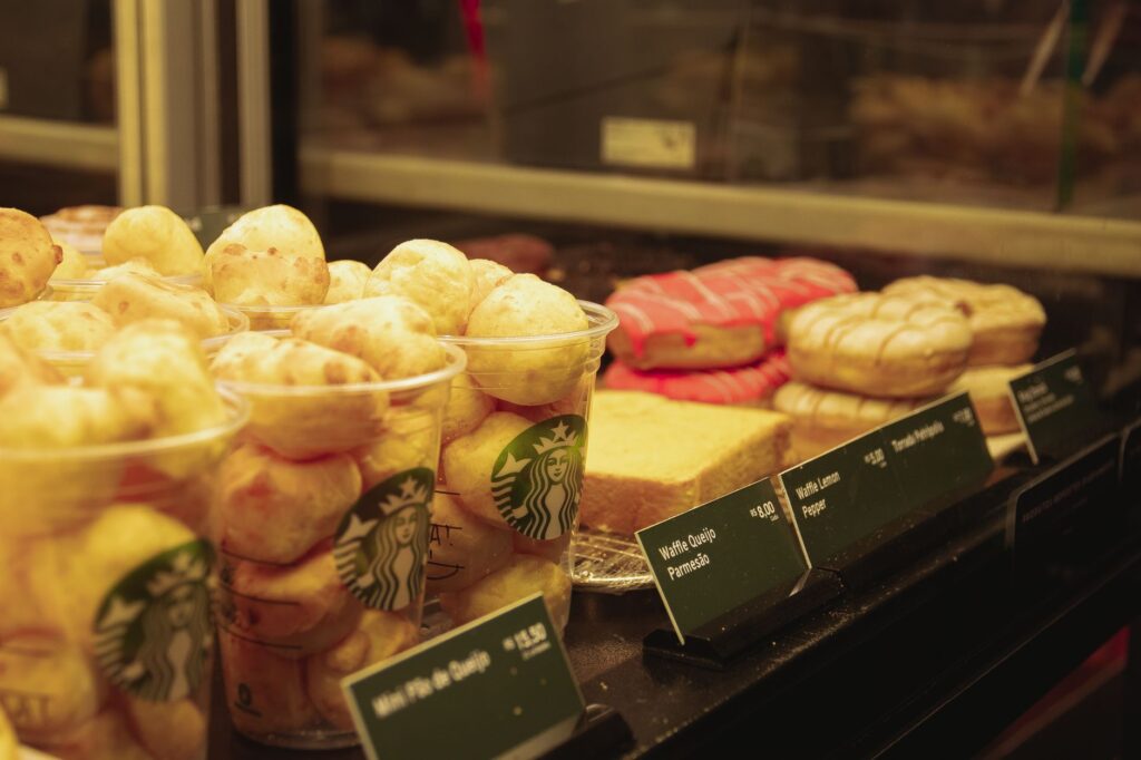 A close-up view of various pastries and baked goods on display in a café setting.
