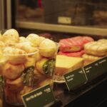 A close-up view of various pastries and baked goods on display in a café setting.