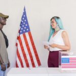 Two diverse young adults engaging in a voting process next to an American flag.