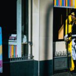 A man in historical military uniform stands outside a fast food outlet, blending past and present.