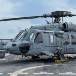 Close-up of Sikorsky SH-60 Seahawk helicopter secured on a naval ship deck.