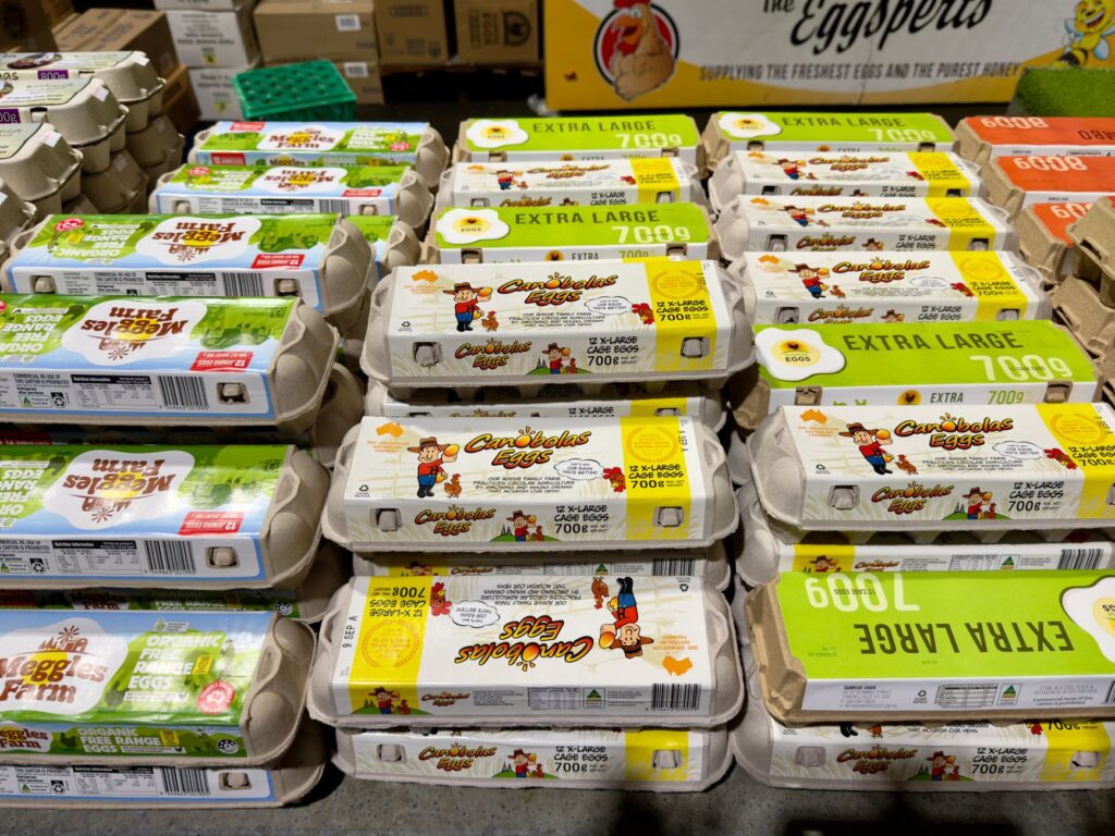 Variety of egg cartons displayed in a Melbourne store, showing organic and extra-large options.