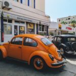 Colorful vintage cars parked at Agil gas station in Tunis, capturing a nostalgic urban scene.