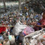 Two women sorting plastic bottles for recycling in Chattogram, Bangladesh.