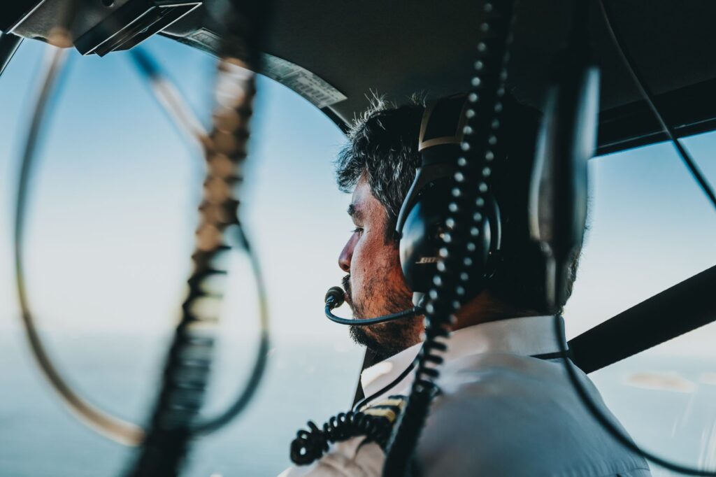 Pilot navigating helicopter over Rio de Janeiro, Brazil with scenic aerial views.