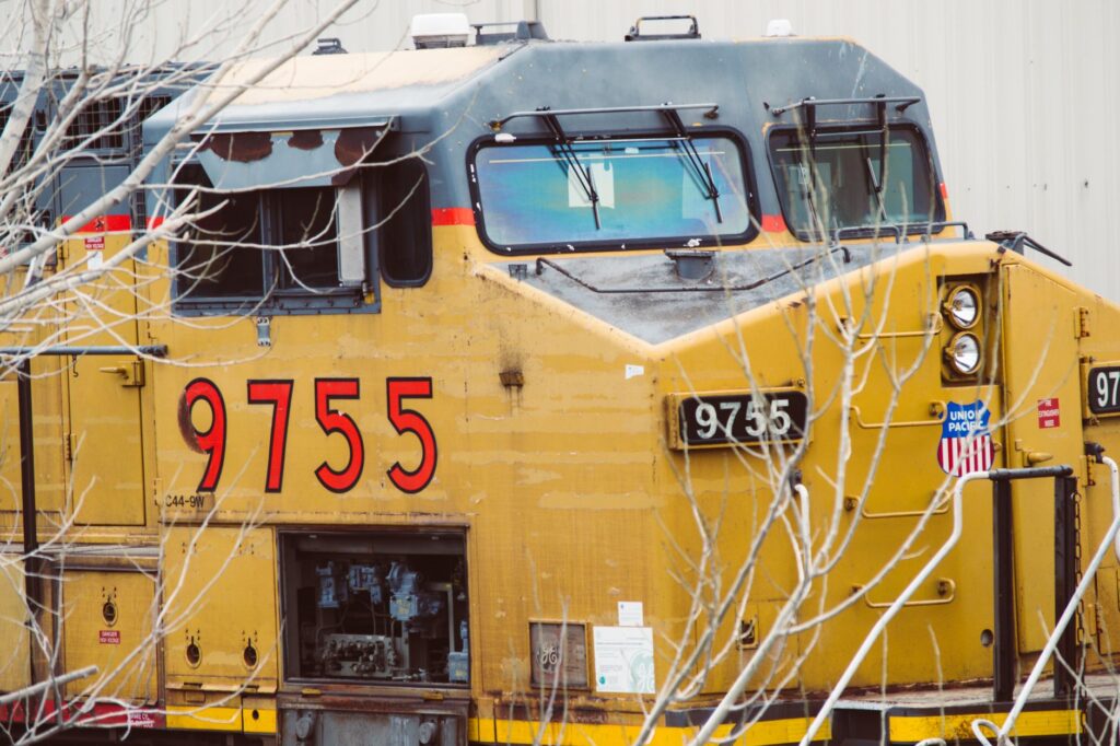 Close-up of a yellow Union Pacific locomotive engine, train number 9755, in an industrial area.