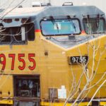 Close-up of a yellow Union Pacific locomotive engine, train number 9755, in an industrial area.