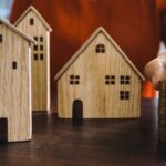 Planning investments with stacked coins and model houses on a table.