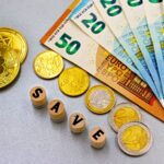 Euro banknotes and Bitcoin coins arranged with 'save' text for finance concept.