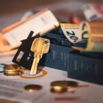 Close-up of house keys, euro bills, and charts symbolizing real estate investment and finance.