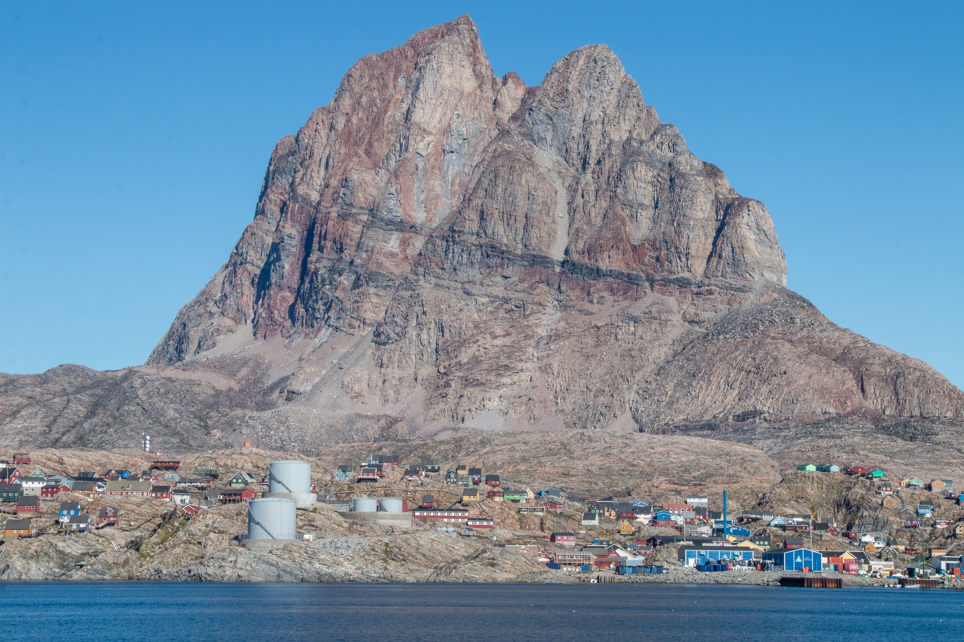 Scenic view of Uummannaq town and soaring mountain cliffs, Greenland.