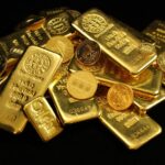 A collection of shining gold bars and coins symbolizing wealth and investment.