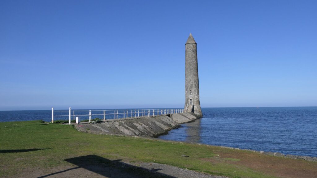 Chaine Memorial Tower on the picturesque Larne coast with blue skies and calm seas.