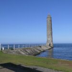 Chaine Memorial Tower on the picturesque Larne coast with blue skies and calm seas.