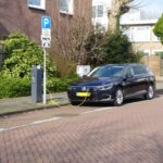 Electric car charging at a street station in Amsterdam, highlighting urban eco-friendliness.
