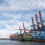 View of container ships and cranes at Hamburg Port, highlighting global trade.